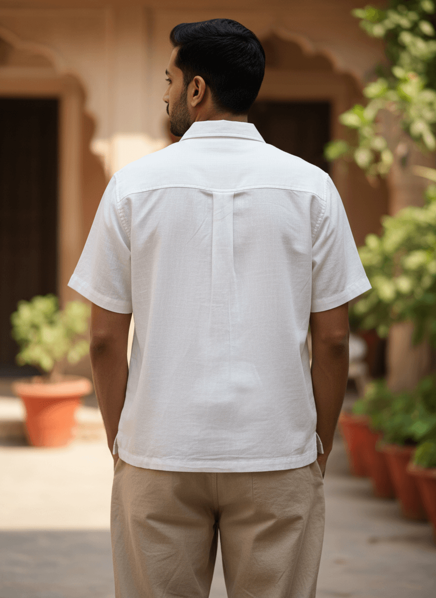 Men's white short-sleeve shirt with black floral embroidery, camp collar, and relaxed fit – front, close-up, and back view.